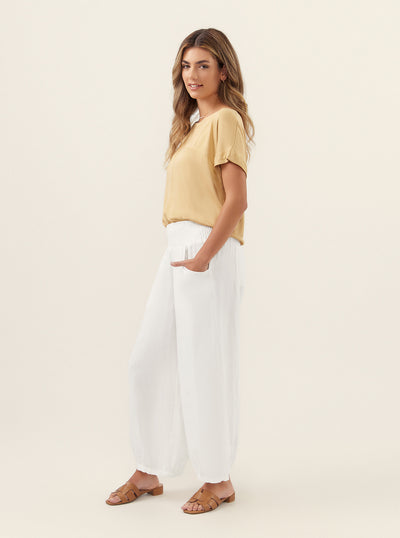 Model wears Sadhu French Linen Pants Regular in White.