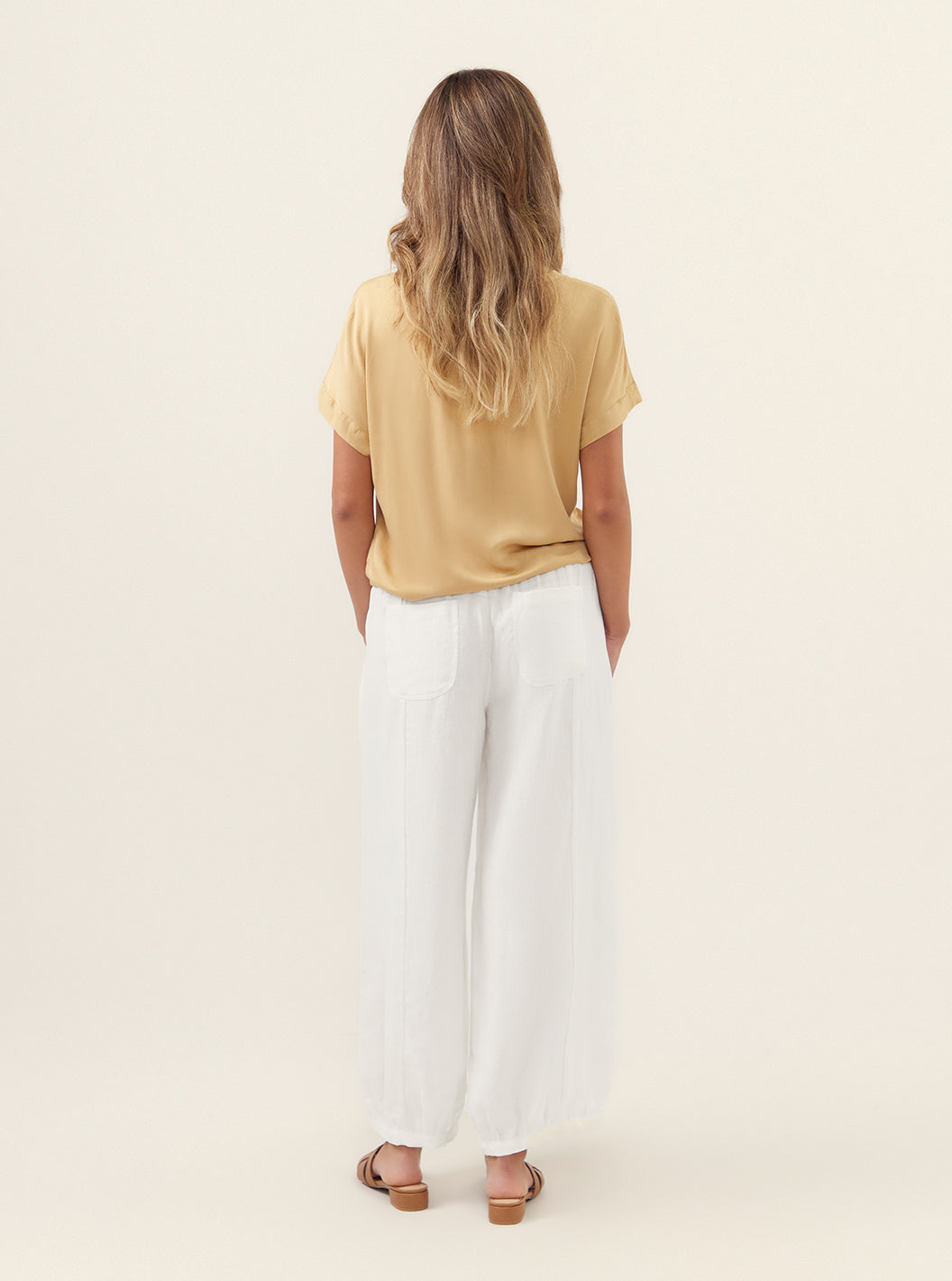 Model wears Sadhu French Linen Pants Regular in White.