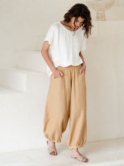 Model wears Sadhu French Linen Pants in Sand