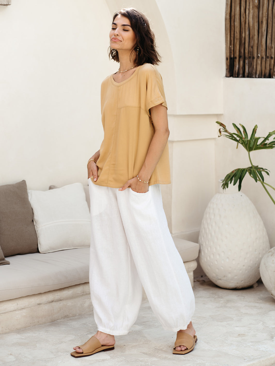 Model wears Sadhu French Linen Pants Regular in White.