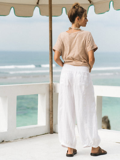 Model wears Sadhu French Linen Pants Regular in White.